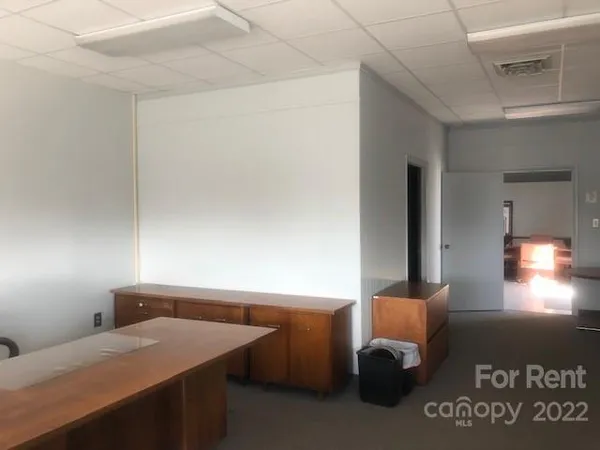 a room with a table chair and lamp