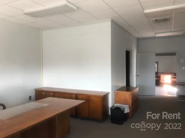 a room with a table chair and lamp