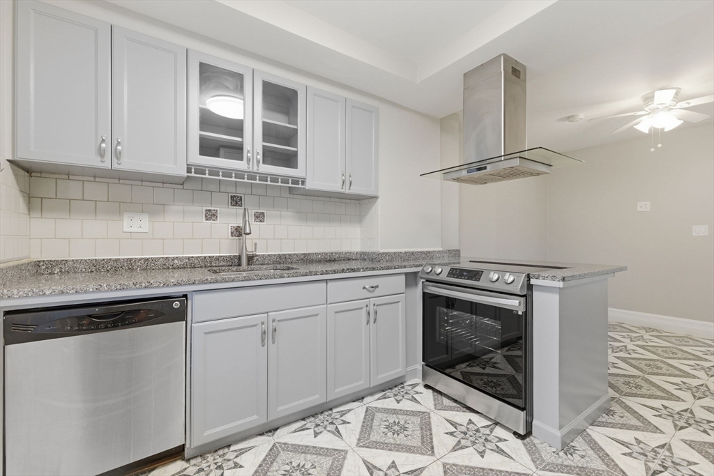 a kitchen with granite countertop a sink stove and cabinets