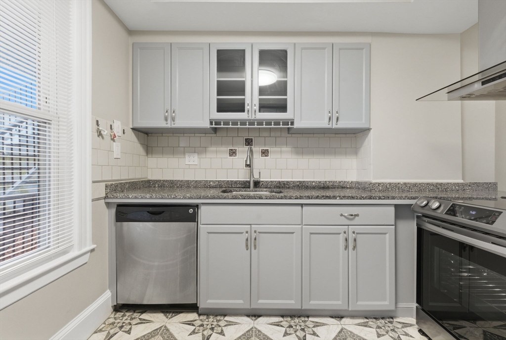 20 Bennett Street, Unit 1L Beverly, MA 01915 - Photo 2 of 22 a kitchen with granite countertop a stove sink and cabinets