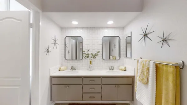 a bathroom with double vanity sinks and a mirror