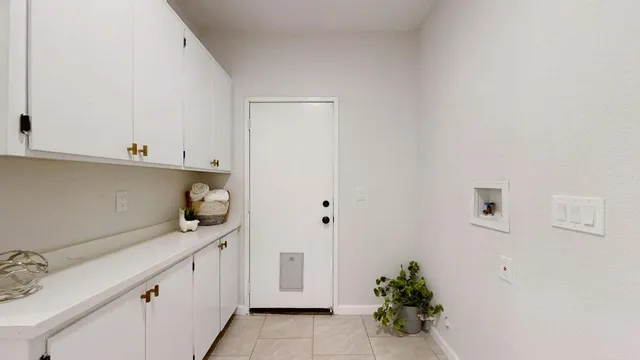 a utility room with cabinets washer and dryer
