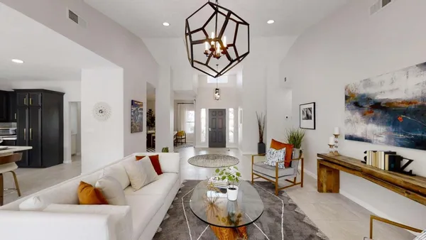 a living room with furniture a flat screen tv and a chandelier