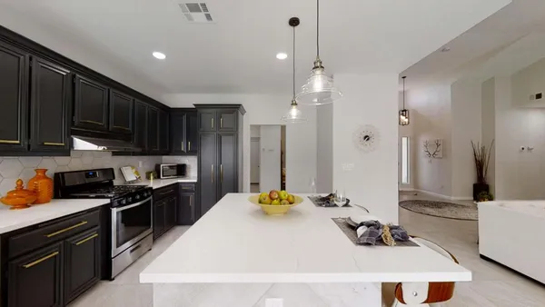 a kitchen with kitchen island granite countertop a sink a stove and refrigerator