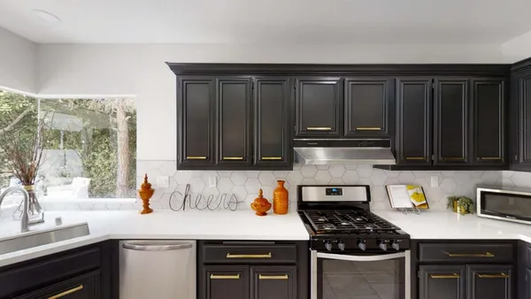 a kitchen with granite countertop a stove a sink and wooden cabinets