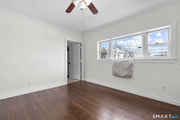 a view of a room with wooden floor and ceiling fan