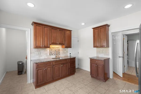 a kitchen with stainless steel appliances granite countertop a refrigerator sink and stove