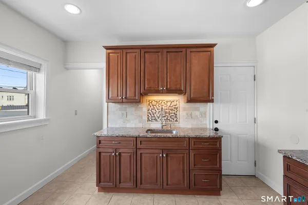 a kitchen with stainless steel appliances granite countertop a refrigerator and a sink
