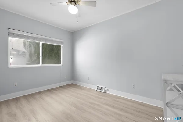 a view of an empty room with wooden floor