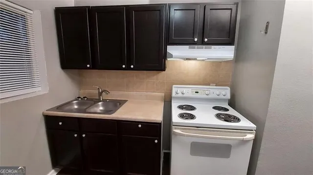 a kitchen with a sink a stove and cabinets