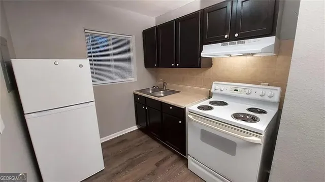 a kitchen with a refrigerator sink stove and cabinets