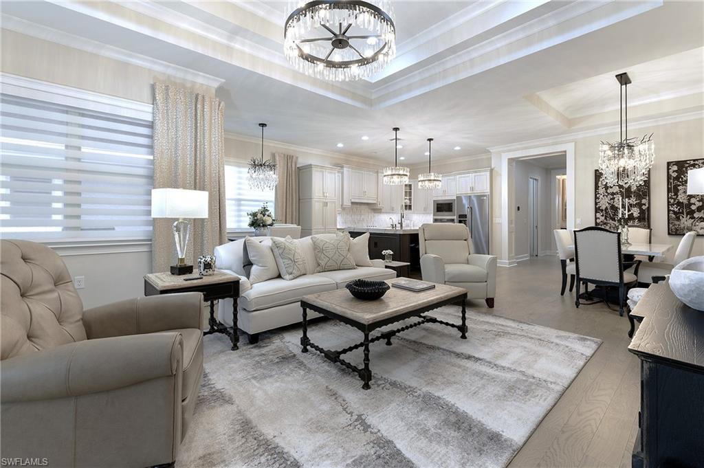 a living room with furniture a chandelier and a table