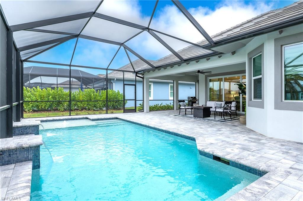 8914 Gustavia Court Naples, FL 34113 - Photo 12 of 23 a view of pool with lawn chairs under an umbrella