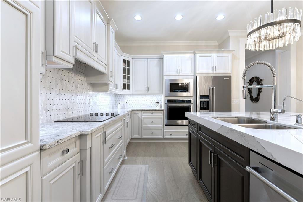8914 Gustavia Court Naples, FL 34113 - Photo 3 of 23 a kitchen with stainless steel appliances granite countertop a sink stove oven and refrigerator