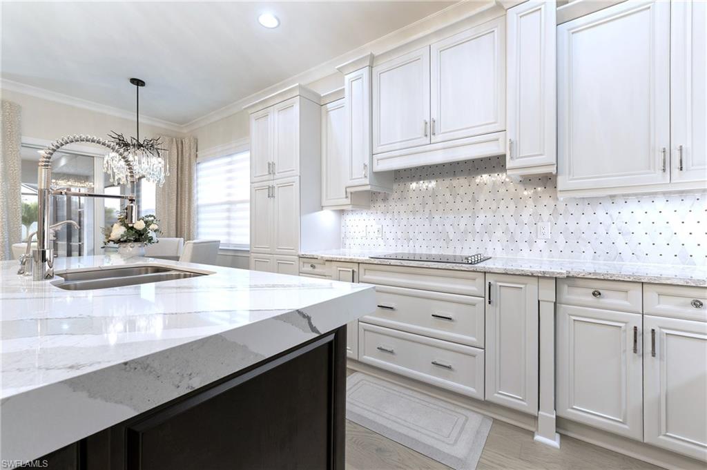8914 Gustavia Court Naples, FL 34113 - Photo 4 of 23 a kitchen with granite countertop white cabinets and white appliances