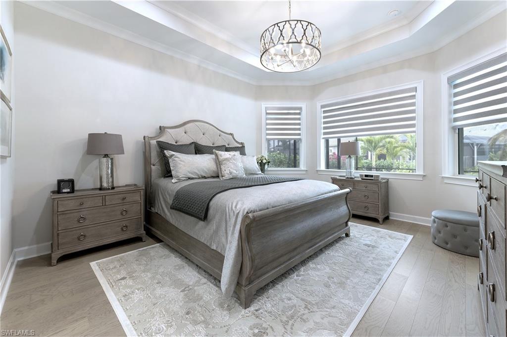 8914 Gustavia Court Naples, FL 34113 - Photo 5 of 23 a bedroom with a bed and a chandelier