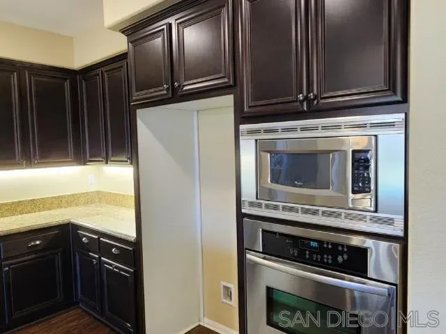 a kitchen with granite countertop cabinets stainless steel appliances and a counter space