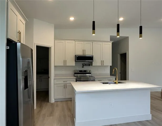 a kitchen with kitchen island a sink stainless steel appliances and cabinets