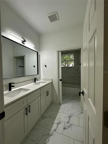 a spacious bathroom with a granite countertop sink mirror and shower