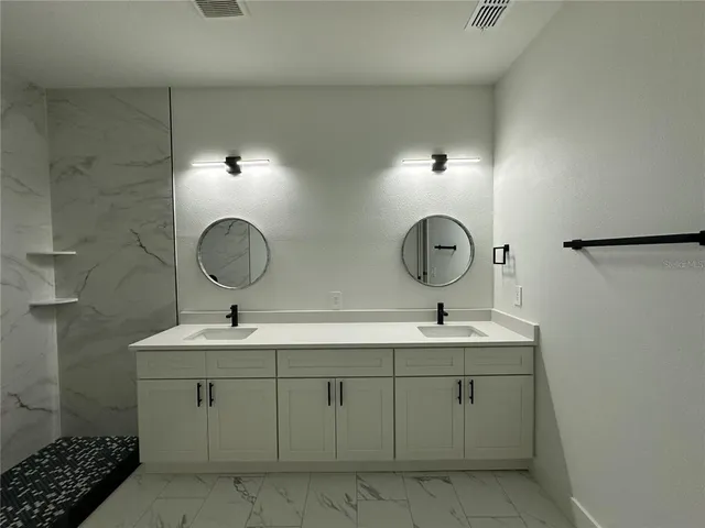 a bathroom with a double vanity sink and a mirror