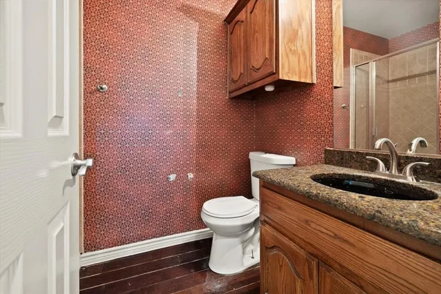 a bathroom with a granite countertop sink a toilet and a mirror