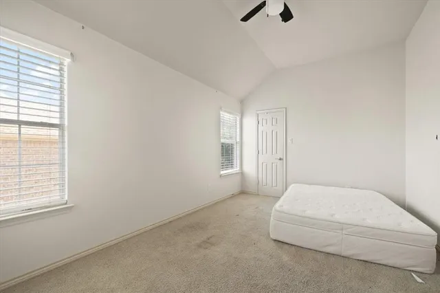 a bedroom with a bed and a chandelier fan
