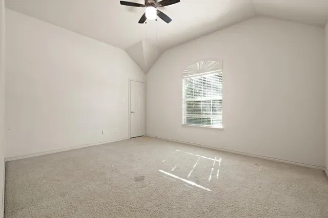 an empty room with a ceiling fan and window
