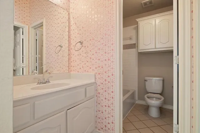 a bathroom with a granite countertop sink a toilet and a mirror
