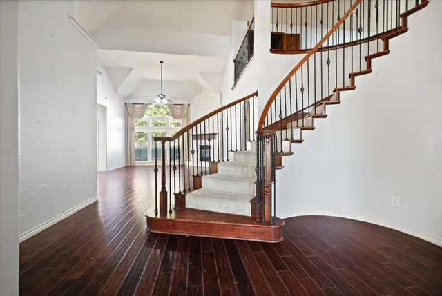 a view of staircase with wooden floor and white walls