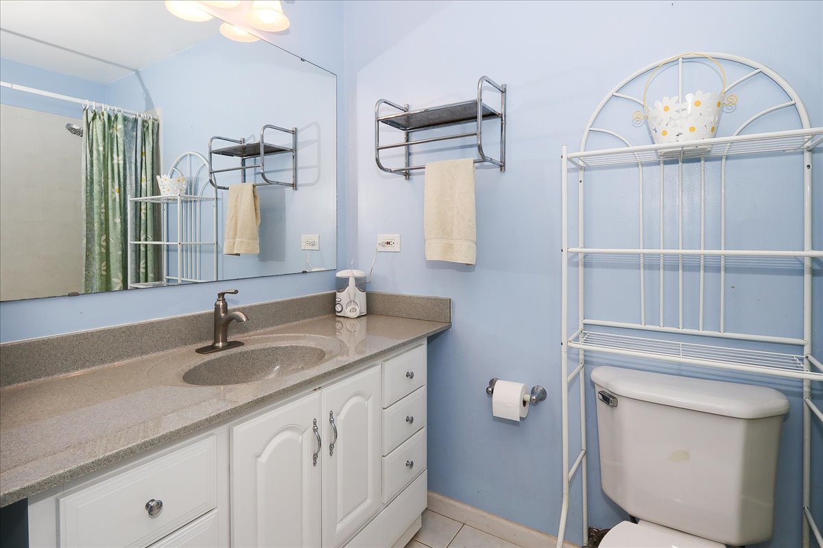 760 Checker Drive Buffalo Grove, IL 60089 - Photo 16 of 29 a bathroom with a granite countertop toilet sink and mirror