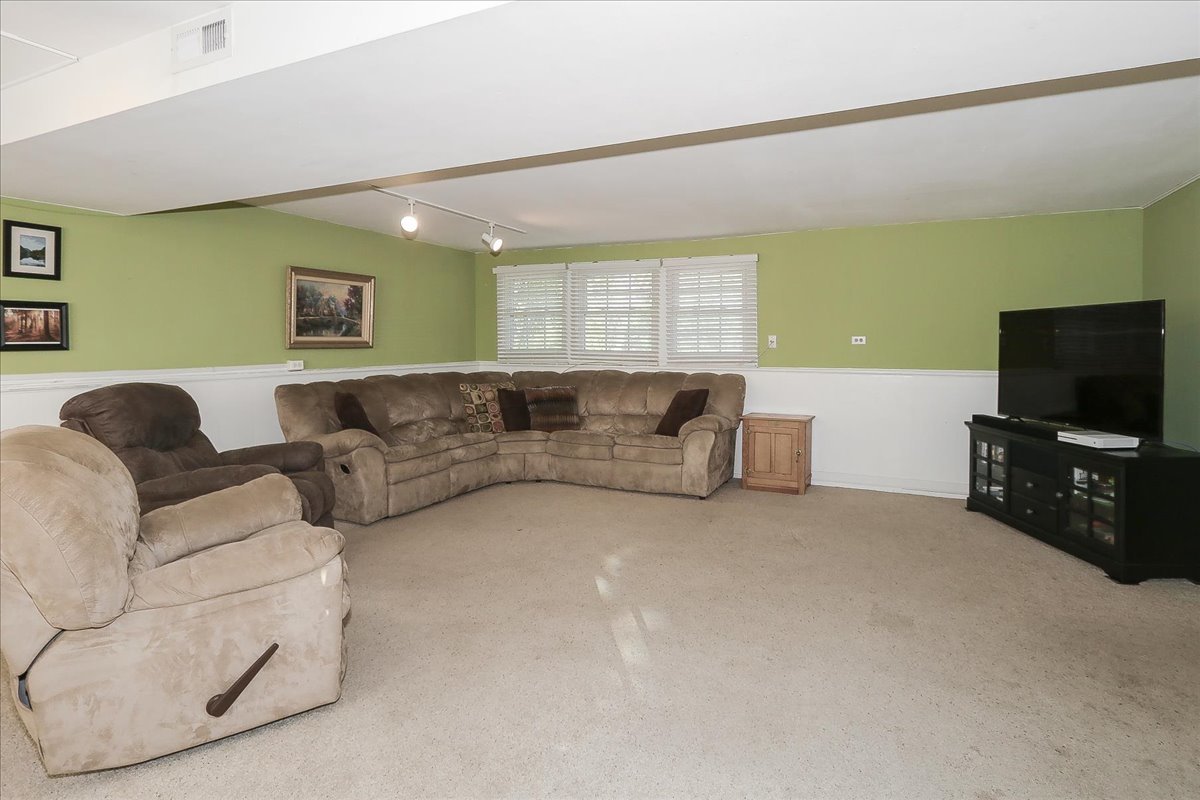 760 Checker Drive Buffalo Grove, IL 60089 - Photo 21 of 29 a living room with furniture and a flat screen tv