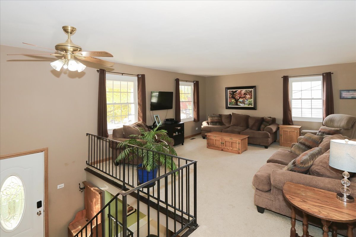 760 Checker Drive Buffalo Grove, IL 60089 - Photo 3 of 29 a living room with furniture a chandelier fan and a window