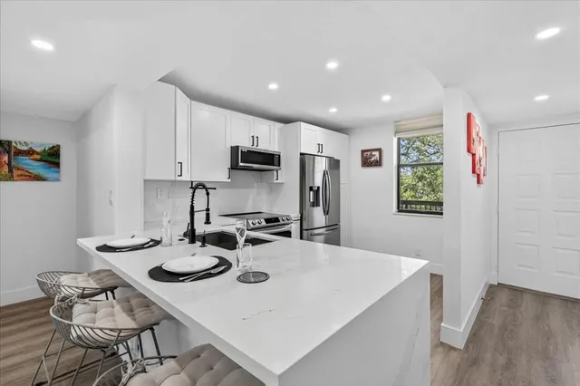 a kitchen with stainless steel appliances a dining table and chairs