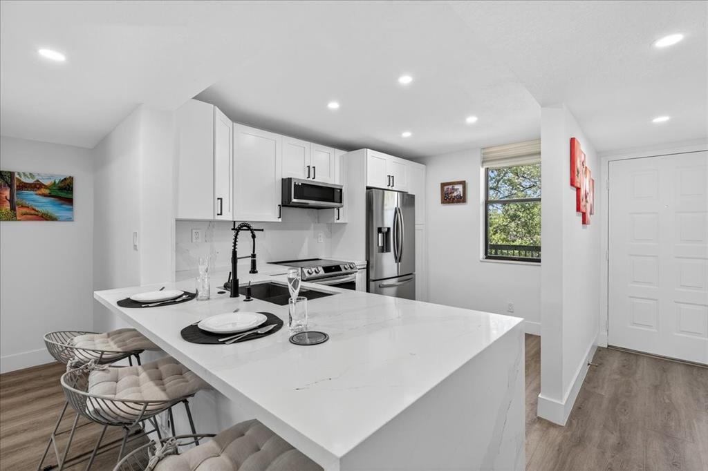 a kitchen with stainless steel appliances a dining table and chairs