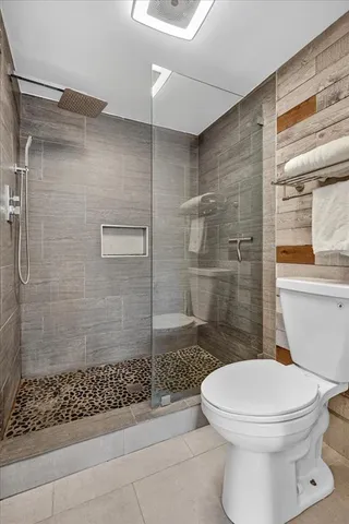 a bathroom with a toilet and a shower