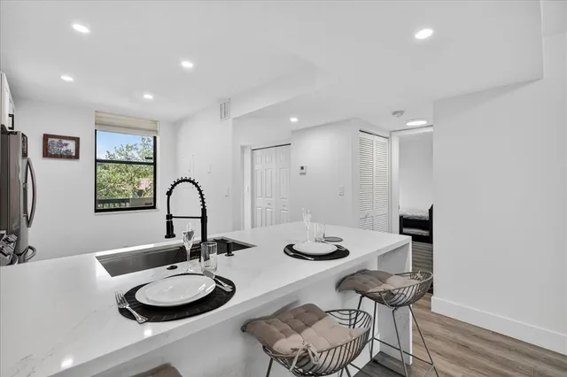 a close view of a sink and a dining table with chairs