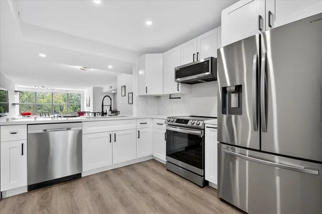 a kitchen with stainless steel appliances a refrigerator sink and microwave