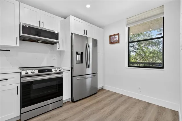 a kitchen with stainless steel appliances a stove a refrigerator and a microwave