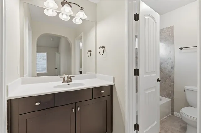 a bathroom with a double vanity sink mirror and toilet