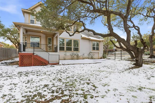 a front view of a house with a yard covered in snow