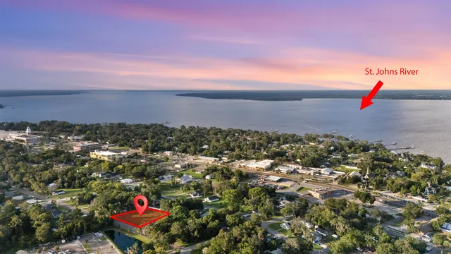 an aerial view of residential houses with outdoor space and trees