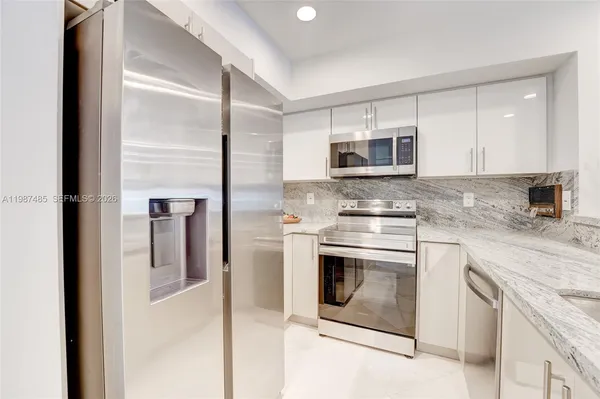 a kitchen with stainless steel appliances granite countertop a sink and stove top oven