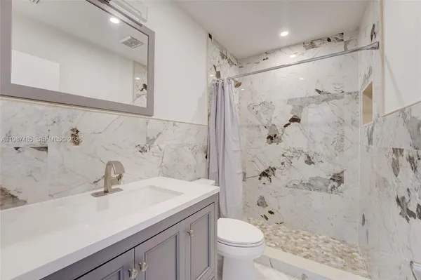 a bathroom with a sink toilet a shower and a mirror