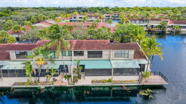 a view of a white house with a large tree