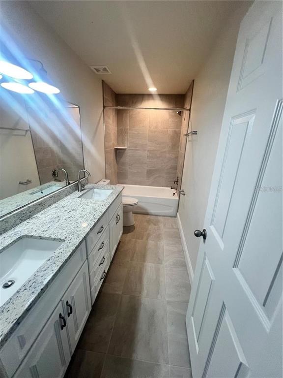 408 South Main Avenue Groveland, FL 34736 - Photo 13 of 15 a bathroom with a granite countertop sink mirror and a bath tub