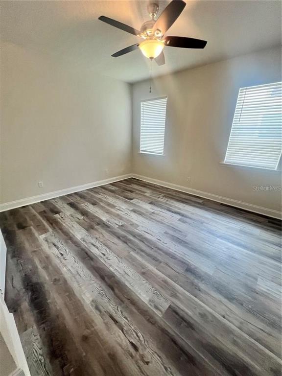 408 South Main Avenue Groveland, FL 34736 - Photo 14 of 15 en empty room with wooden floor fan and windows