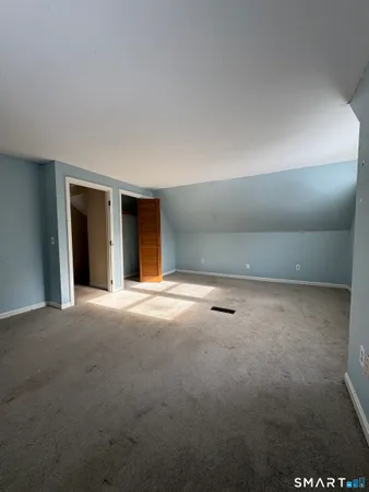 a view of an empty room with window and stairs