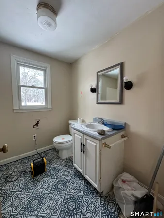 a bathroom with a toilet a sink and mirror