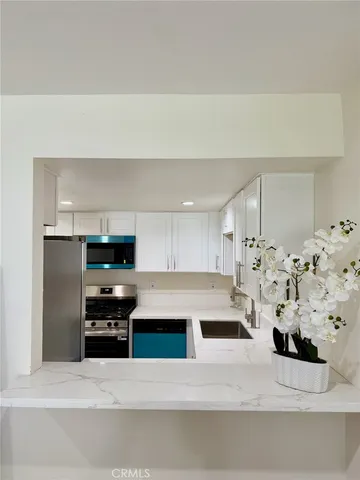 a kitchen with stainless steel appliances kitchen island sink refrigerator and stove