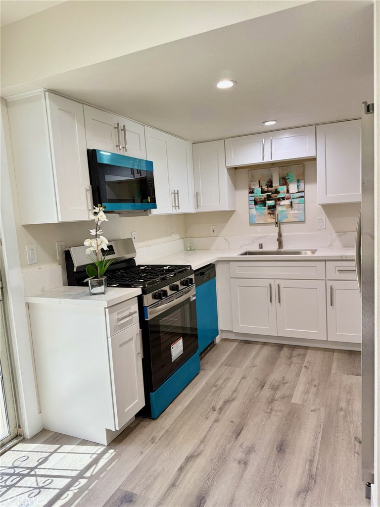 810 West Compton Boulevard, Unit 7 Compton, CA 90220 - Photo 5 of 16 a kitchen with stainless steel appliances a sink stove and white cabinets